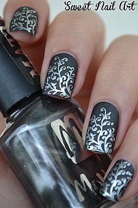 diseño de uñas negro con flores plateadas